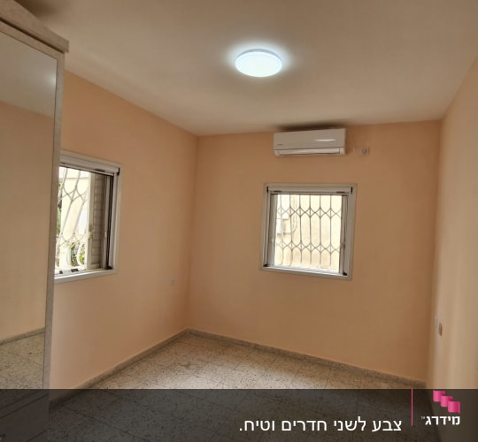 חדר מגורים עם קירות צבועים בגוון אפרסק ותקרה לבנה